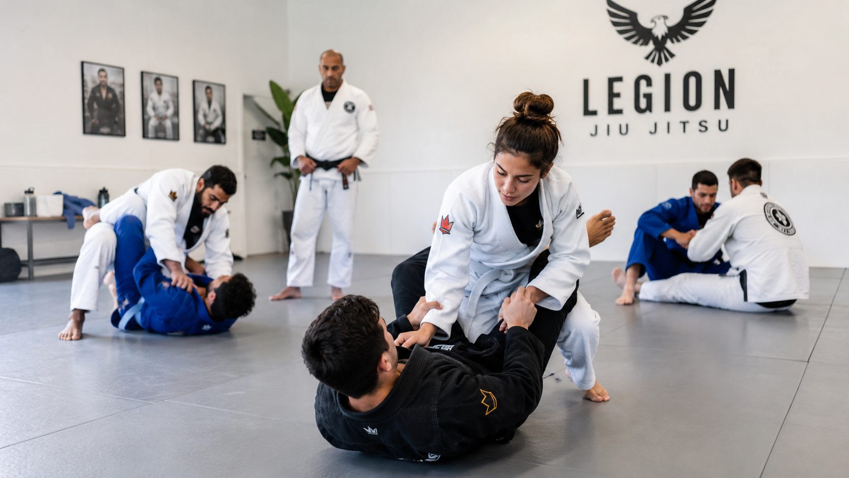 A beginners class training in pairs across the academy mats.